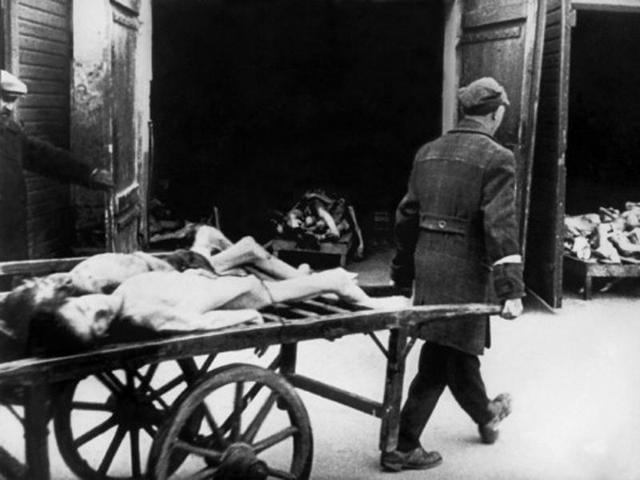 A man carries away the bodies of dead Jews in the Ghetto of Warsaw in 1943, where people began to die of hunger in the streets. Every morning, funeral carts collected a dozen or more corpses on the streets. (AFP Archive)