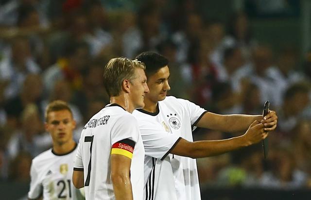 A fan, wearing a Germany shirt with ‘Schweinsteiger’ across the shoulders, ran onto the pitch, took a selfie with the World Cup winner and casually jogged off. (Reuters Photo)