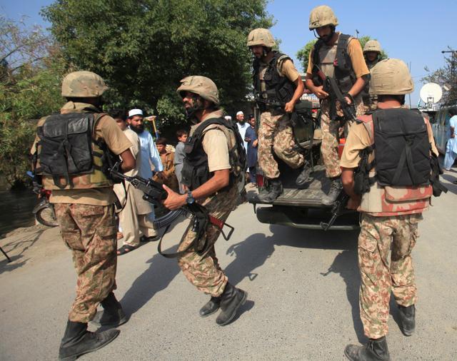 Pakistani soldiers arrive at a street after suicide bombers attacked a Christian colony near Peshawar on Friday. (Reuters) Pakistani soldiers arrive at a street after suicide bombers attacked a Christian colony near Peshawar on Friday. (Reuters)