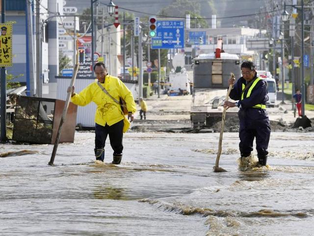 People wade through the flooded road following heavy rain from Typhoon Lionrock in Minamifurano, the northern island of Hokkaido, Japan. (AP Photo)