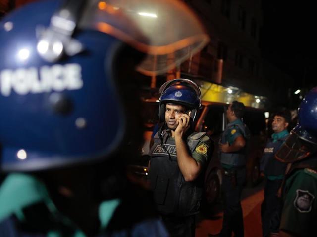 A Bangladeshi policeman speaks on a mobile phone at the scene of a raid on a suspected militant hideout in Dhaka on Friday. (AP) A Bangladeshi policeman speaks on a mobile phone at the scene of a raid on a suspected militant hideout in Dhaka on Friday. (AP)