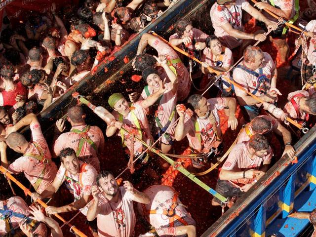 However, there was a break in festivities under the rule of Francisco Franco, who banned it since it had no religious significance. The festival promptly returned in the 1970s after his death. Revellers on a truck throw tomatoes into the crowd. (REUTERS)