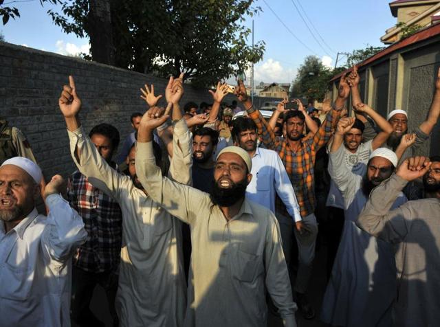 Supporters of Syed Ali Geelani, the Chairman of All Parties Hurriyat (Freedom) Conference (APHC) raise pro-freedom slogans in front of the cavalcade of the all-party delegation of parliamentarians outside his residence on Sep 4, 2016.(Waseem Andrabi / HT Photo)