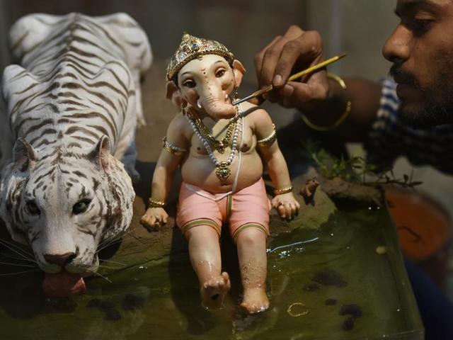MIGHTY LORD: Artist Vinod Shinde gives finishing touches to an idol made of clay. (Anshuman Poyrekar/HT) 