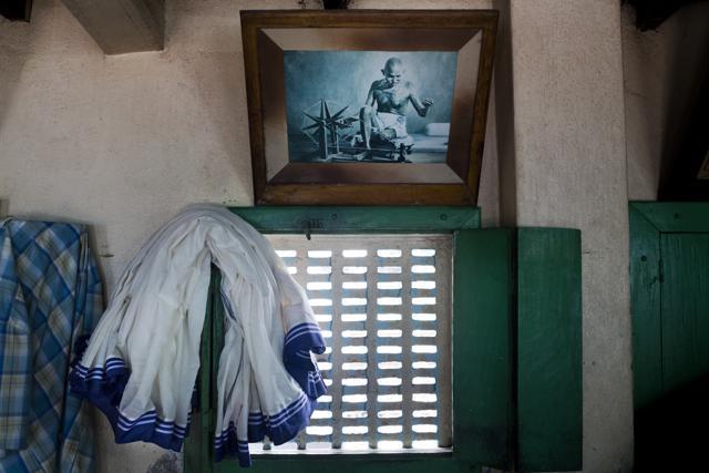 Iconic blue-bordered saris, worn by nuns of the Missionaries of Charity, hang next a picture of Mahatma Gandhi inside the Gandhiji Prem Nivas, a Leprosy centre conducted by Missionaries of Charity in Titagarh, north of Kolkata on Saturday. (AP) Iconic blue-bordered saris, worn by nuns of the Missionaries of Charity, hang next a picture of Mahatma Gandhi inside the Gandhiji Prem Nivas, a Leprosy centre conducted by Missionaries of Charity in Titagarh, north of Kolkata on Saturday. (AP)