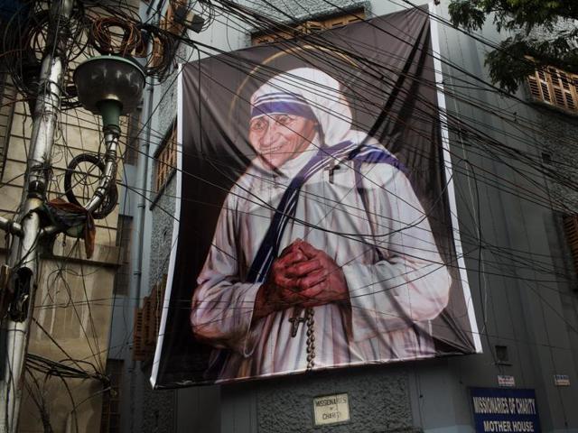 Nuns of the Missionaries of Charity in Kolkata walk past a large banner of Mother Teresa ahead of her canonisation.(Reuters) Nuns of the Missionaries of Charity in Kolkata walk past a large banner of Mother Teresa ahead of her canonisation.(Reuters)