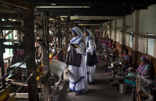 Nuns from the Missionaries of Charity watch weavers at Gandhiji Prem Nivas, or Gandhiji House of Love, in Titagarh, north of Kolkata on Saturday. The center is a leprosy hospital, rehabilitation and vocational training center run by Missionaries of Charity. (AP) Nuns from the Missionaries of Charity watch weavers at Gandhiji Prem Nivas, or Gandhiji House of Love, in Titagarh, north of Kolkata on Saturday. The center is a leprosy hospital, rehabilitation and vocational training center run by Missionaries of Charity. (AP)