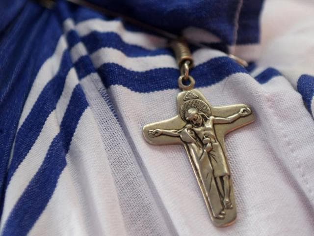A cross is hangs from the sari of an Indian nun from the Catholic Order of the Missionaries of Charity as she arrives to watch the live telecast of canonisation of Mother Teresa from Rome, at the Mother House in Kolkata on September 4, 2016. Singing nuns and followers clutching flowers flocked to Mother Teresa's tomb in the Indian city of Kolkata to celebrate her proclamation as a saint at the Vatican People started gathering from early morning at Mother House in Kolkata for a special mass for the "Saint of the Gutters" ahead of the ceremony due at St Peter's Basilica. / AFP PHOTO / Dibyangshu SARKAR (AFP) 