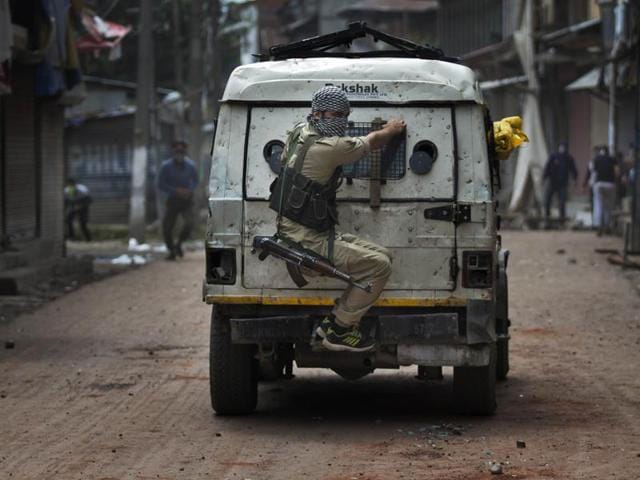 A police officer takes cover behind an armoured vehicle as Kashmiri protesters throw stones at him during a protest in Srinagar on August 30. (AP) A police officer takes cover behind an armoured vehicle as Kashmiri protesters throw stones at him during a protest in Srinagar on August 30. (AP)