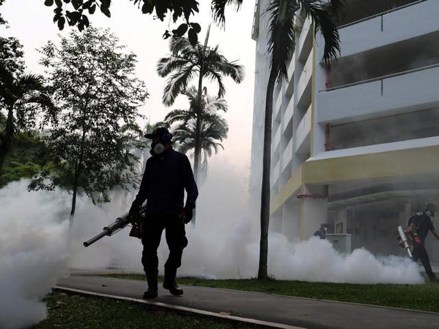 A worker fogs in the housing estate at Aljunied Crescent in Singapore. (AFP Photo)