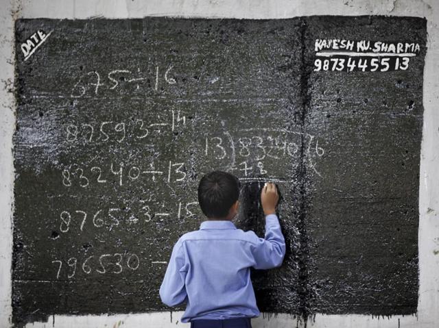 A student in Rajesh Gupta’s class writes on a blackboard. (Raj K Raj/HT PHOTO)