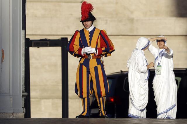 Nuns of Mother Teresa's Missionaries of Charity stand near a Swiss guard prior to the start of a mass celebrated by Pope Francis. (AP Photo) Nuns of Mother Teresa's Missionaries of Charity stand near a Swiss guard prior to the start of a mass celebrated by Pope Francis. (AP Photo)