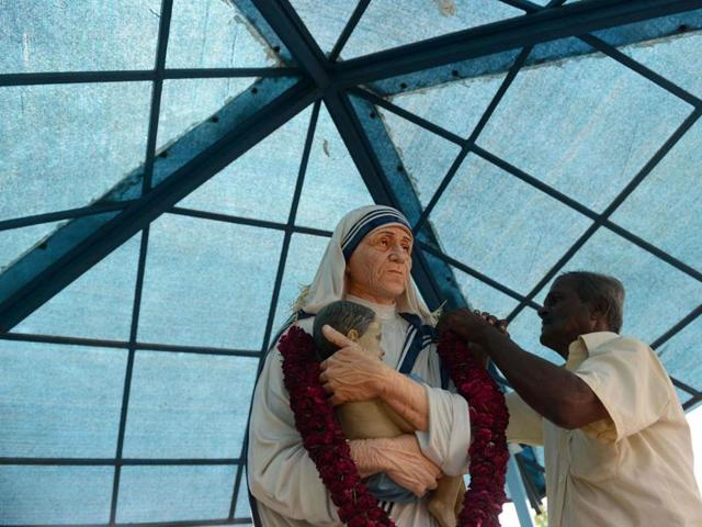 People wait to pay obeisance to a statue of Mother Teresa after mass at a church in Mumbai. (AFP Photo) People wait to pay obeisance to a statue of Mother Teresa after mass at a church in Mumbai. (AFP Photo)