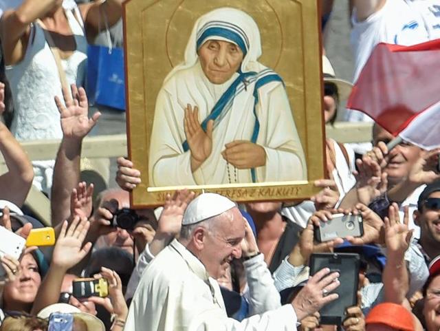 Pope Francis (C) waves to faithful as he leaves after a Holy Mass and canonisation of Mother Teresa of Kolkata, on Saint Peter's Square in the Vatican, on September 4, 2016. Mother Teresa, the nun whose work with the dying and destitute of Kolkata made her a global icon of Christian charity, was made a saint on September 4, 2016. Her elevation to Roman Catholicism's celestial pantheon came in a canonisation mass in St Peter's square in the Vatican that was presided over by Pope Francis in the presence of 100,000 pilgrims. / AFP PHOTO / ANDREAS SOLARO (AFP) 
