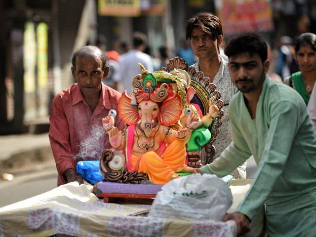 A family takes their Ganesha idol home from a workshop at Girgaum. (Pratik Chorge/ HT photo)