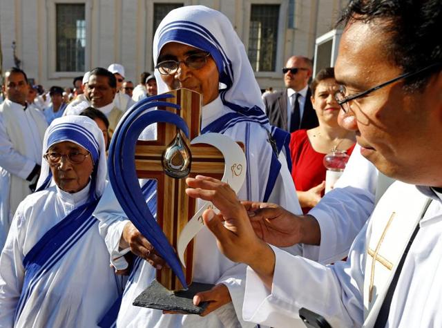 Indian Christians and nuns gathered to pay their respects by a portrait of Mother Teresa in Siliguri before her canonisation.(AFP)