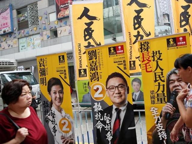 People walk past banners candidates on election day for Hong Kong’s legislative council. (REUTERS) People walk past banners candidates on election day for Hong Kong’s legislative council. (REUTERS)