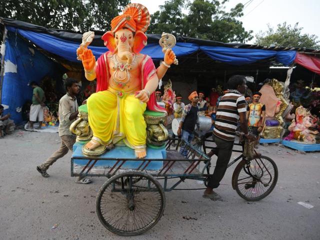 An idol  being transported on a cycle rickshaw in Ahmedabad. Several government agencies and non-governmental organisations have urged people to follow environment-friendly festivities and not immerse the idols in water bodies. (Ajit Solanki/AP) 