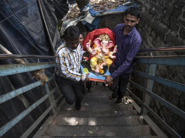 Devotees carry an idol on Ganesh Chaturthi at Chinchipokhli in Mumbai.  Around 40,000 more homes in Mumbai will host Ganpati this year, taking the tally of household idols to 2.25 lakh in the city. (Satish Bate/HT PHOTO) 