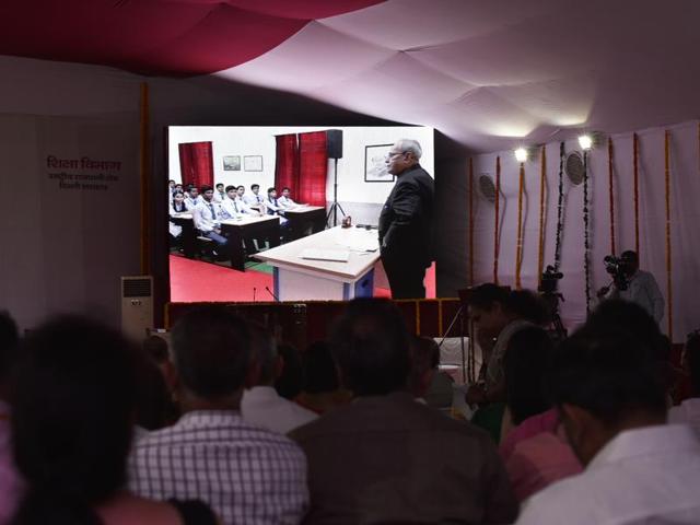 People watch on a digital screen as President Pranab Mukherjee teaches students of Class 12 of Dr Rajendra Prasad Sarvodaya Vidyalaya at President's Estate in New Delhi on Monday. (Vipin Kumar/HT PHOTO)