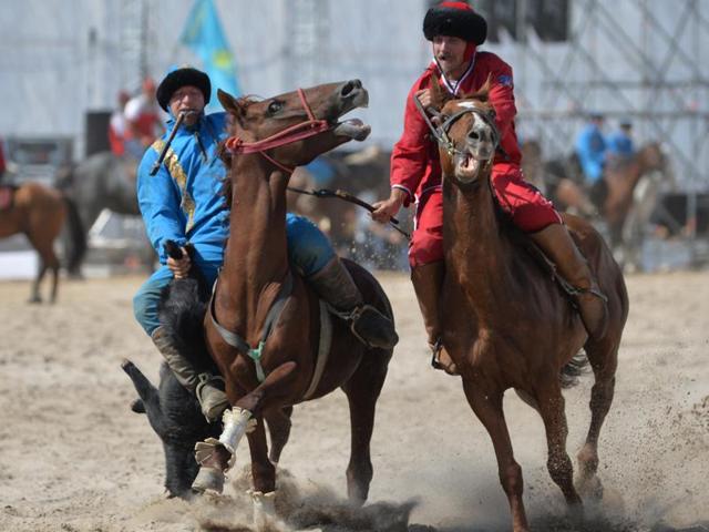 Kazakh and US (red) riders play the traditional Central Asian sport Buzkashi. (AFP Photo)