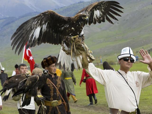Participants hold golden eagles for an eagle hunt during the second World Nomad Games. (AP photo)