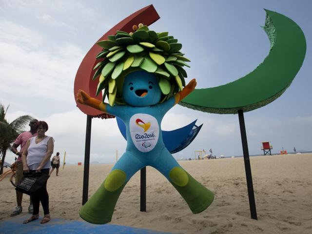 People walk next to the Paralympic symbol, displayed at Copacabana beach. (REUTERS) People walk next to the Paralympic symbol, displayed at Copacabana beach. (REUTERS)