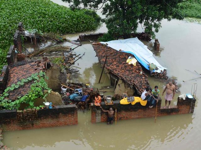 A family sit at their destroyed house amidst the floodwaters after heavy rains in Gaya.(AFP Photo) A family sit at their destroyed house amidst the floodwaters after heavy rains in Gaya.(AFP Photo)