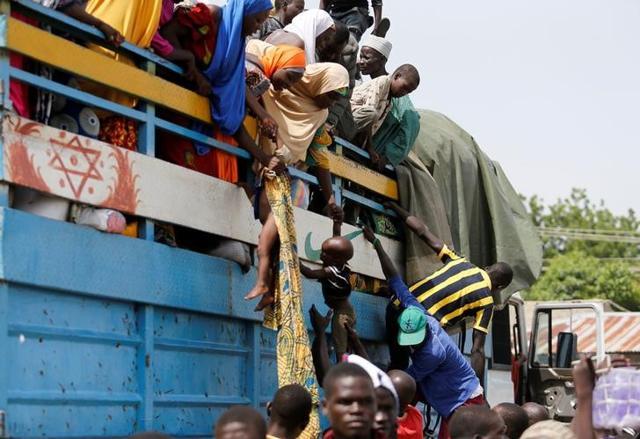 Parents lower their children from a loaded truck at a local bus station in Maiduguri, Borno State, Nigeria. (Reuters) Parents lower their children from a loaded truck at a local bus station in Maiduguri, Borno State, Nigeria. (Reuters)