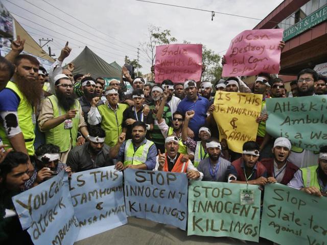 Volunteers hold placards as they shout slogans during a protest outside a hospital in Srinagar.(AP)