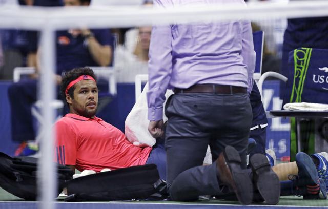 Jo-Wilfried Tsonga is attended to by a trainer shortly before he retired due to injury. (AP)
