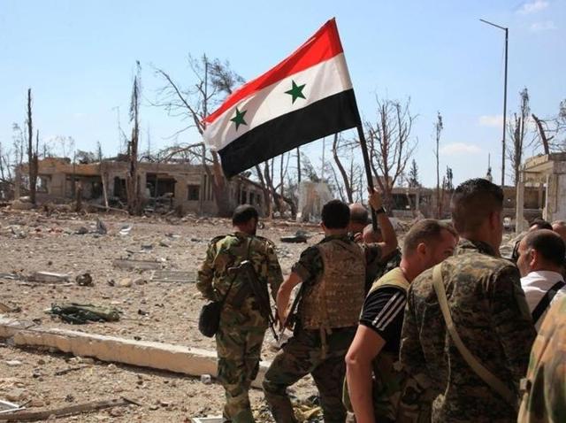 Forces loyal to Syria's President Bashar al-Assad walk at a military complex as one of them holds up a Syrian national flag, in Aleppo. (Reuters Photo) Forces loyal to Syria's President Bashar al-Assad walk at a military complex as one of them holds up a Syrian national flag, in Aleppo. (Reuters Photo)