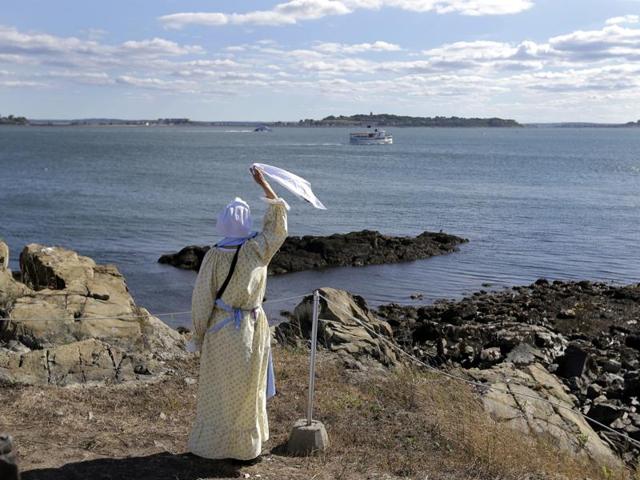 Sally Snowman waves to a cruise boat from Little Brewster Island in Boston Harbor. (AP)