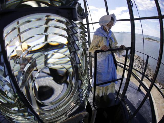 In this photo, Sally looks outside the lantern room while standing next to the Fresnel lens. (AP)
