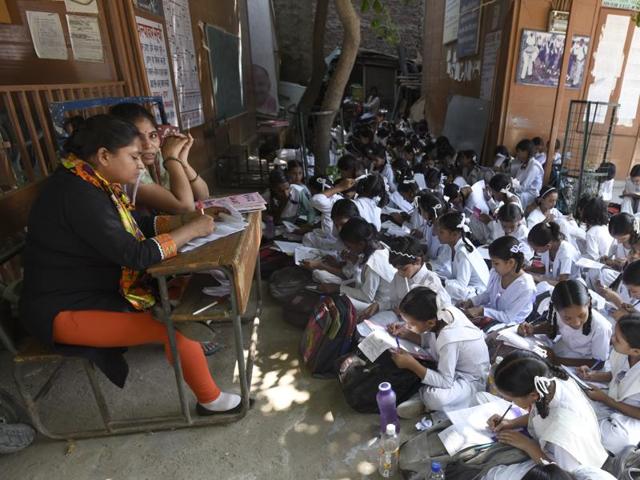 Unable to accommodate all students in classrooms, teachers of a government senior secondary school in north east Delhi’s Mustafabad hold classes out in the open.(Sonu Mehta/HT Photo)