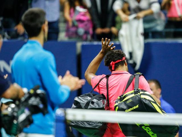 Djokovic applauds as Tsonga walks off court. Tsonga retired from the match with a left knee injury while trailing 6-3, 6-2. (AFP)