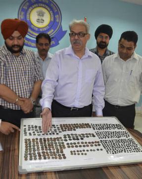 Customs commissioner Capt Sanjay Gahlot and others officials showing the coins at their office in Amritsar on Wednesday. (Sameer Sehgal/HT Photo)