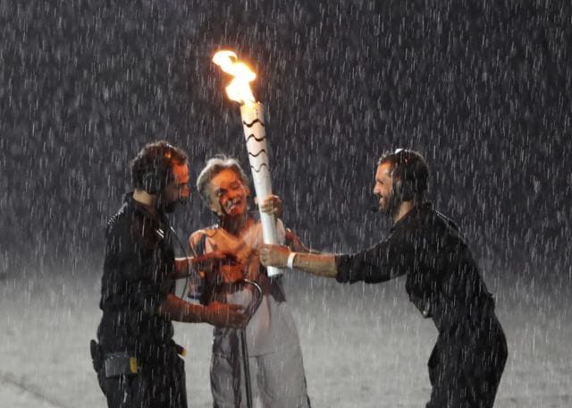 Marcia Malsar is assisted after falling while carrying the torch. (REUTERS) Marcia Malsar is assisted after falling while carrying the torch. (REUTERS)
