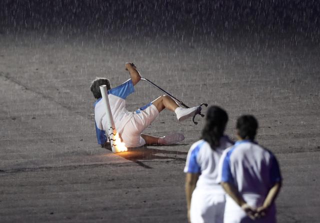 Brazilian paralympic runner Marcia Malsar falls while carrying the torch as rain falls during the opening ceremony. (REUTERS) Brazilian paralympic runner Marcia Malsar falls while carrying the torch as rain falls during the opening ceremony. (REUTERS)