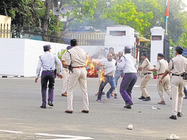 Police rush to the rescue of NCP worker Manoj Tripathi after he set himself afire at the gates of Raj Bhawan in Bhopal on Wednesday. (HT photo) Police rush to the rescue of NCP worker Manoj Tripathi after he set himself afire at the gates of Raj Bhawan in Bhopal on Wednesday. (HT photo)