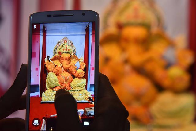 A devotee takes a photo of a Ganpati idol in a cooperative housing society in Malad.(Vidya Subramanian/HT PHOTO)
