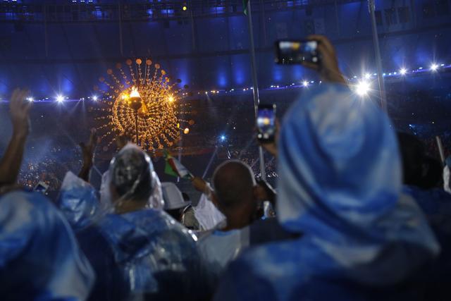 Performers take pictures of the Olympic flame being lit. (AP) Performers take pictures of the Olympic flame being lit. (AP)