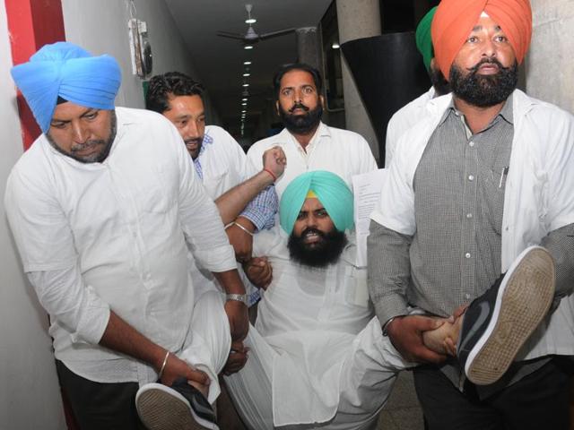 Independent MLA Simarjeet Singh Bains being removed by marshals from the Punjab assembly on Friday.(Keshav Singh/HT Photo)