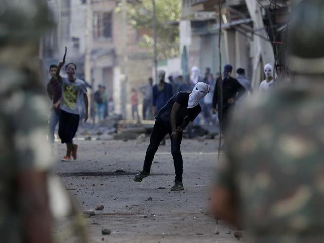 A masked Kashmiri protester throws stones at security forces personnel during a protest in Srinagar. (AP) A masked Kashmiri protester throws stones at security forces personnel during a protest in Srinagar. (AP)