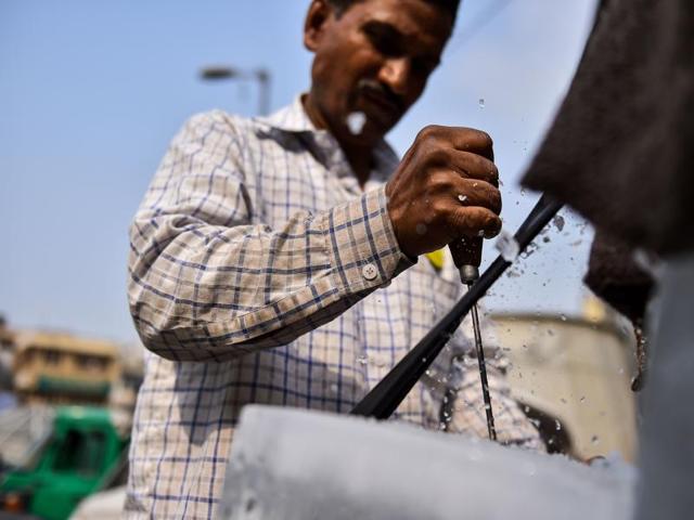 52-year-old Ram Babu chops an ice block into cubes as he sells it in the old quarters of New Delhi. (AFP) 52-year-old Ram Babu chops an ice block into cubes as he sells it in the old quarters of New Delhi. (AFP)