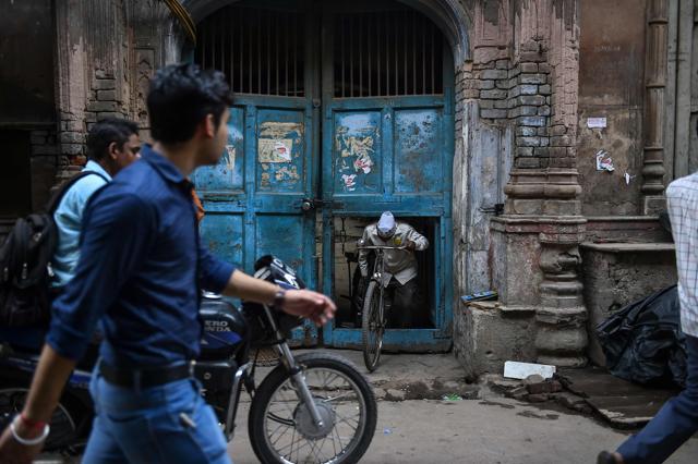 Ram Babu takes out his delivery bicycle from a neighbour's garage. (AFP) Ram Babu takes out his delivery bicycle from a neighbour's garage. (AFP)