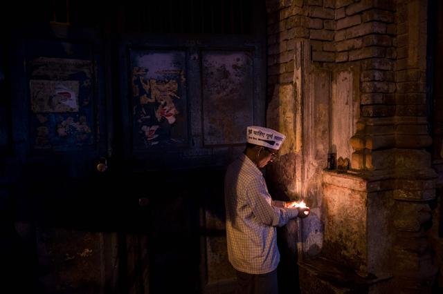 He lights a lamp as he prays at his makeshift ice shop. (AFP) He lights a lamp as he prays at his makeshift ice shop. (AFP)