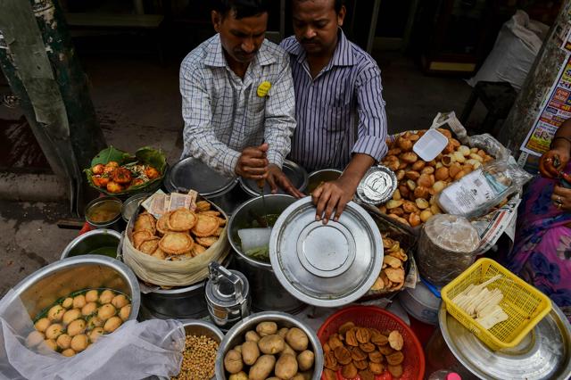 Babu chops an ice block into cubes at a roadside food vendor. (AFP) Babu chops an ice block into cubes at a roadside food vendor. (AFP)