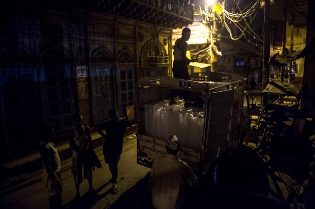 Ram Babu (front) receives a delivery of ice blocks at his makeshift ice shop in the old quarters of New Delhi. (AFP) Ram Babu (front) receives a delivery of ice blocks at his makeshift ice shop in the old quarters of New Delhi. (AFP)