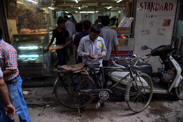 Ram Babu arranges his money and receipts as he finishes his delivery. (AFP) Ram Babu arranges his money and receipts as he finishes his delivery. (AFP)